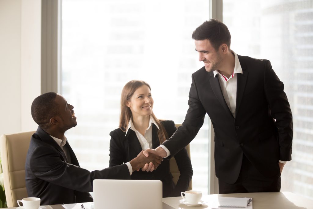 Two business professionals shaking hands representing a reinsurance broking partnership